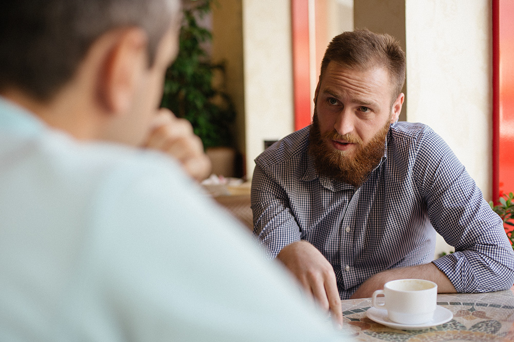 two men at a table discussing plans